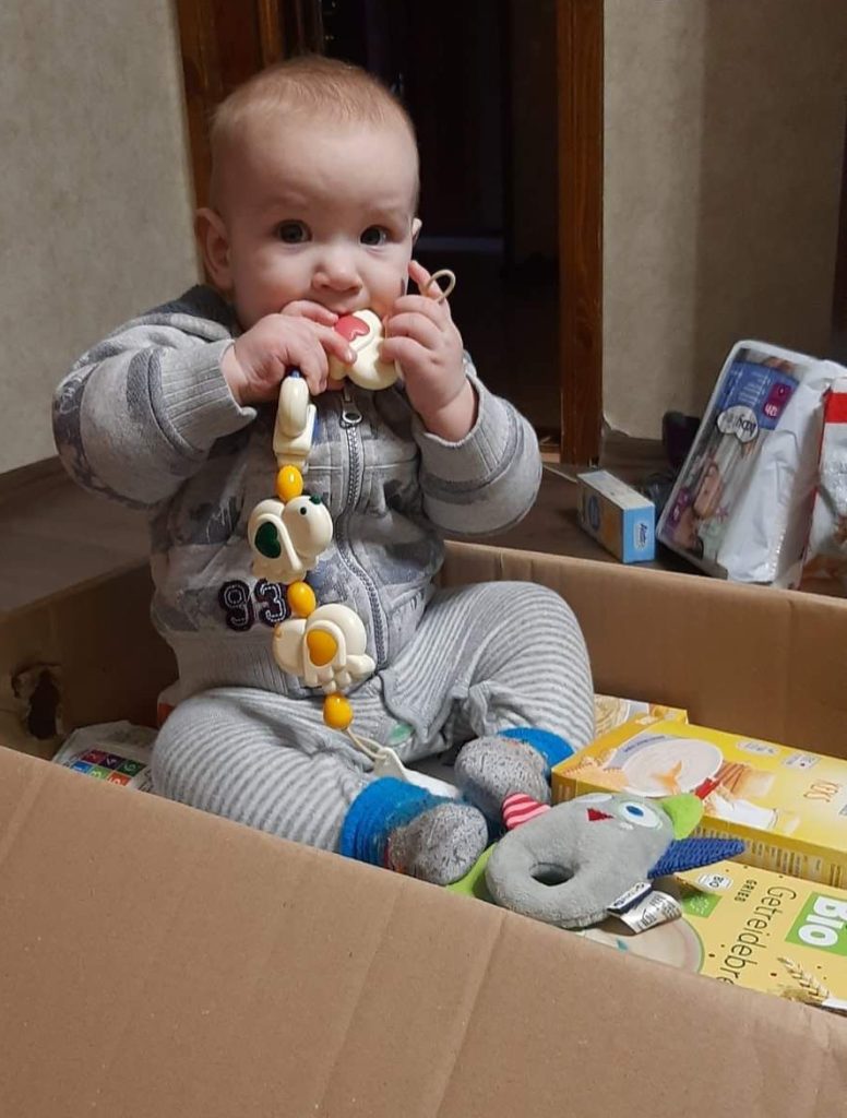Ein ukrainisches Baby sitzt in Cherson in einem Karton mit Hilfsgütern