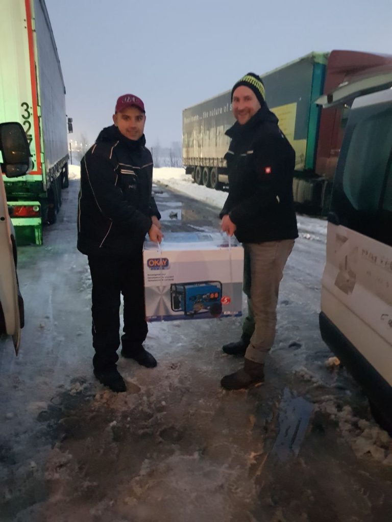 Unser Volunteer Marco (r.) übergibt einen Generator in der Ukraine an unser ukrainisches Vereinsmitglied Ruslan